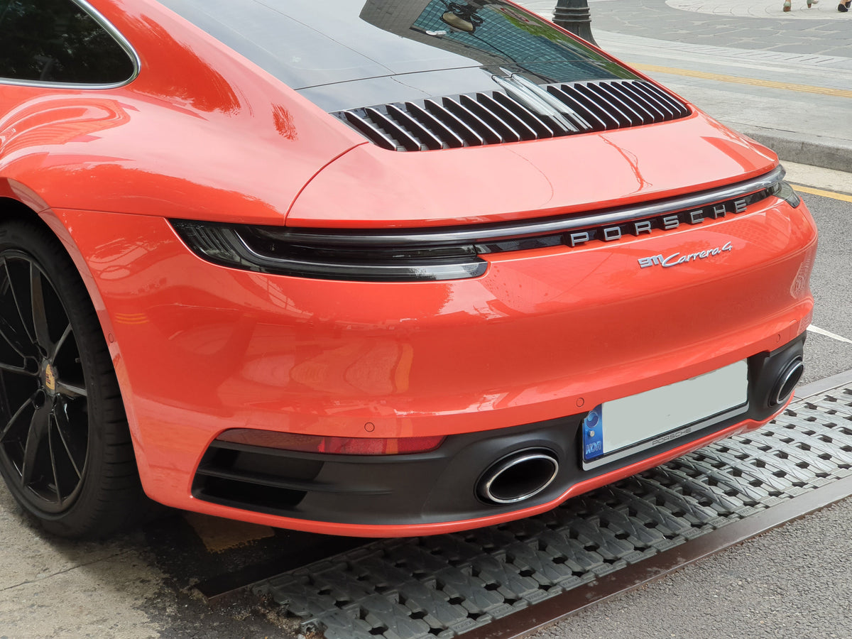Rear view of an orange Porsche 992 911 Carrera 4 coupe